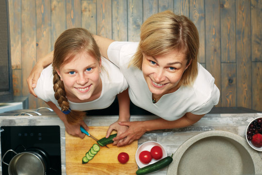 A cute child and mom cook healthy food together. View from above