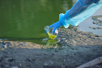 Close-up environmentalist hand of a researcher in a process of taking a sample of contaminated...