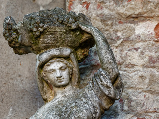 old sculpture of a girl with a pitcher on his shoulder