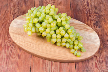 Sultana grapes cluster on the oval wooden serving board