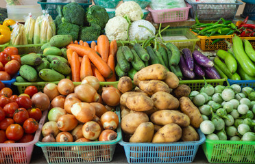 Obraz na płótnie Canvas Thai market grocery - carrots, potatoes, onion, mango, tomatoes, eggplants, chile, cauliflower, broccoli, ears of corn