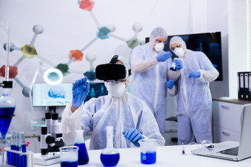 Female scientist using virtual reality goggles simualtion for chemical experiment