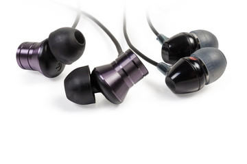 Different black in-ear earphones close-up on white background