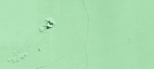 Old cracked mint wall. Painted texture background in trendy mint color. Banner