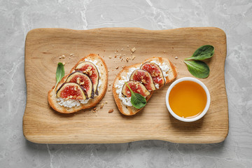 Bruschettas with cheese, figs and honey served on marble table, top view