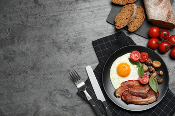 Fototapeta na wymiar Tasty breakfast with fried egg served on grey table, flat lay. Space for text