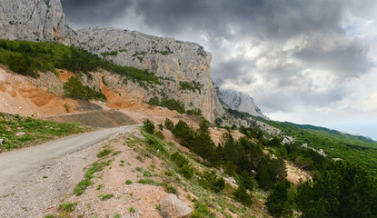 Fototapeta na wymiar Old mountain road near the cliffs, landslide from the slope