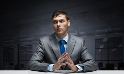 Young man folded hands and having serious face