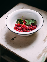 Ripe raspberry with leaf in old retro plate