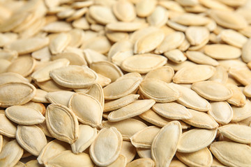 Raw unpeeled pumpkin seeds as background, closeup