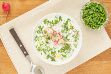 Summer cold yogurt soup okroshka. Traditional Russian soup okroshka in bowl on wooden background. Top view. 