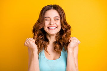 Photo of lucky trendy cheerful beautiful attractive charming sweet pretty rejoicing girlfriend having won lottery while wearing turquoise singlet being isolated with yellow vibrant color background