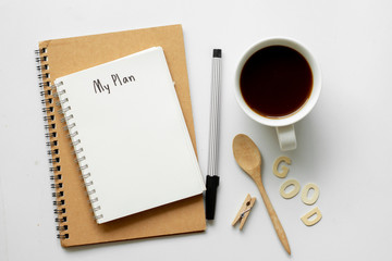 Notebook with My Plan text on top of white notebook with coffee on office desk .Life planning concept.