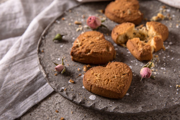 Biscuit hearts. Crispy and crumbly delicious cookies with natural ingredients: flour, nuts, seeds, pieces of chocolate, cocoa, fruit jams. Spring flower still life