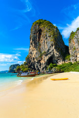 Limestone karst rocks at Ao Phra Nang Beach with Thai traditional wooden longtail boat on Railay...