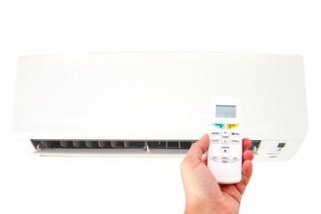 Modern airconditioner unit with a hand holding a remote.
