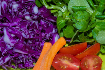 Salad with tomato, red cabbage, spinach and carrot.