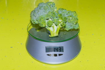 Weighing broccoli on a scale.