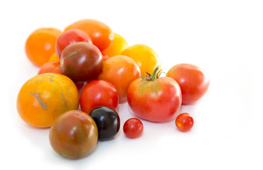 Natural fresh farm multi-colored tomatoes on a white background.