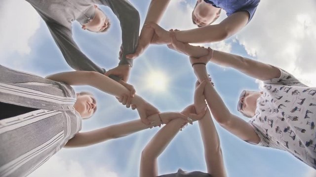 Friends join their hands in a circle. The concept of strong friendship.