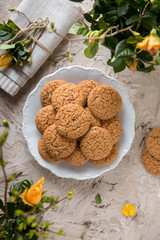 Oatmeal Biscuit. Crispy and crumbly delicious cookies with natural ingredients: flour, nuts, seeds, pieces of chocolate, cocoa, fruit jams. Spring flower still life
