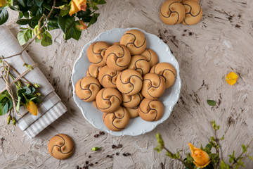 Сhocolate nut biscuit. Crispy and crumbly delicious cookies with natural ingredients: flour, nuts, seeds, pieces of chocolate, cocoa, fruit jams. Spring Flower Still Life