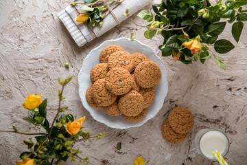Oatmeal Biscuit. Crispy and crumbly delicious cookies with natural ingredients: flour, nuts, seeds, pieces of chocolate, cocoa, fruit jams. Spring flower still life