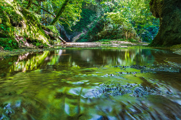 Waterfall surrounded by greenery. Acquacaduta. Friuli, Italy