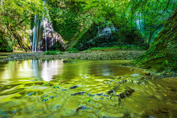 Obraz premium Waterfall surrounded by greenery. Acquacaduta. Friuli, Italy