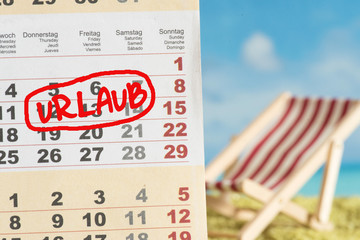 Strand und Kalender mit dem Hinweis auf Urlaub