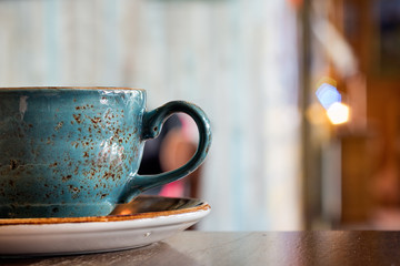 Close up of a ceramic coffee cup on a table, side view.