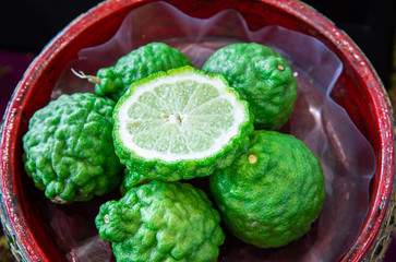 Closeup fresh kaffir limes and cut in half, one of popular Thai herb.