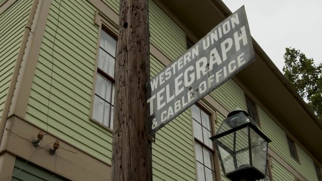 Old telegraph line with Western Union period sign in early American historical village