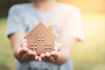 Small home model on woman hand.