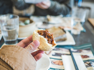 Hafl bitten meat prok bun (or dumplling) with hand