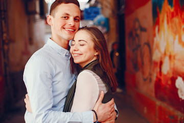 Fototapeta premium handsome young guy in a blue shirt standing in a urban summer city along with her cute girl in a white shirt