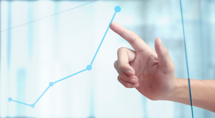 Hand touching a graphs of financial indicator chart
