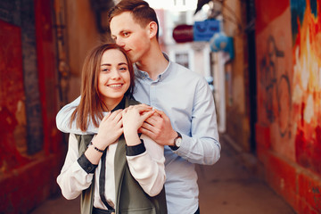 handsome young guy in a blue shirt standing in a urban summer city along with her cute girl in a white shirt
