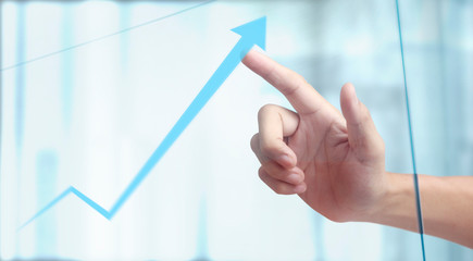 Hand touching a graphs of financial indicator chart