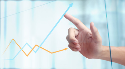 Hand touching a graphs of financial indicator chart
