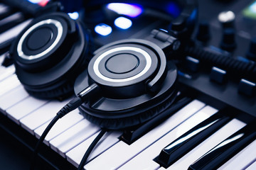 Play and listen music with headphones and synthesizer piano board.Professional studio setero...