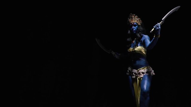 Dramatic lighting, indian goddess Kali is walking with two blades in hand