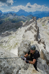attractive female climber on a steep Via Ferrata in the Italian Dolomites