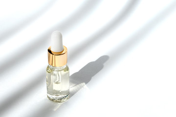 Anti aging serum with collagen and peptides in glass bottle with dropper on white background with...
