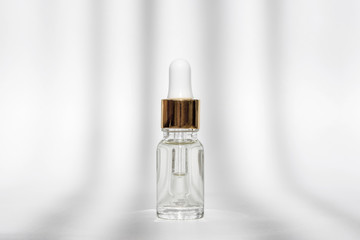 Anti aging serum with collagen and peptides in glass bottle with dropper on white background with shadows. Anti-age product, luxury body care and organic science concept.