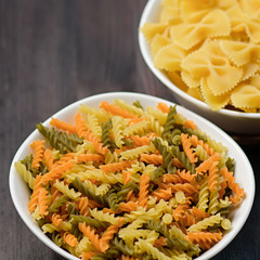Various pasta types on wooden background. Raw pasta assortment, top view, copy space