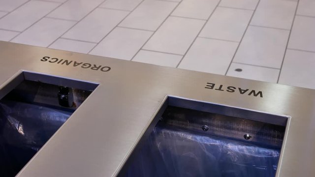 Motion of people throwing trash to the garbage can inside shopping mall with 4k resolution.