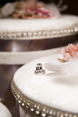 two wedding rings with precious stones lie on a box with gifts. Vertical frame