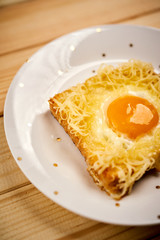 Delicious toast with fried egg on wooden kitchen table