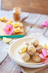 Healthy raw vegan candies with coconut and lemon, concept of tasty vegetarian food